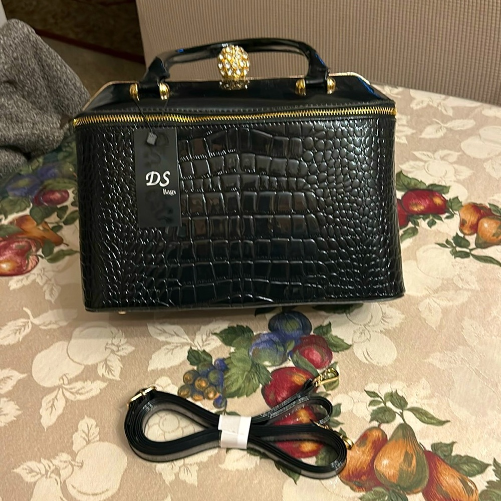 Black purse includes over shoulder strap